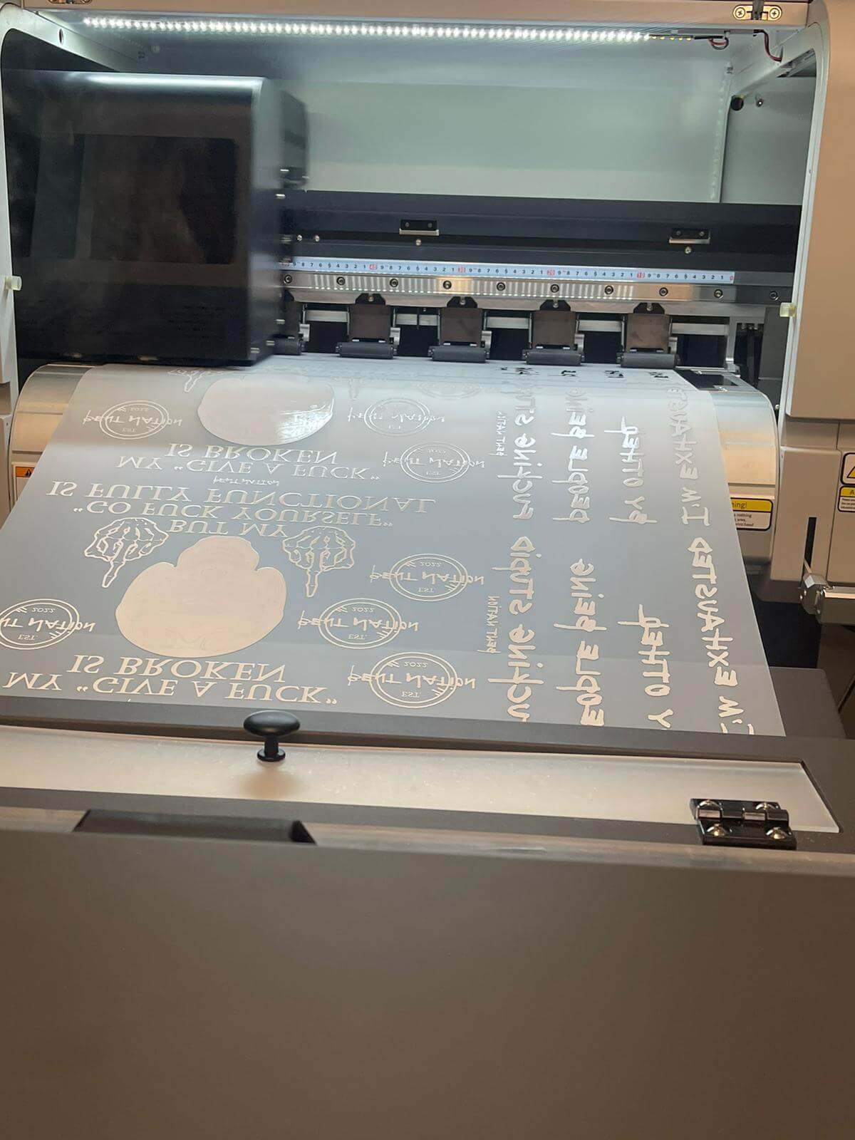 DTF printer in action producing custom designs for high-quality transfers and gang sheets.