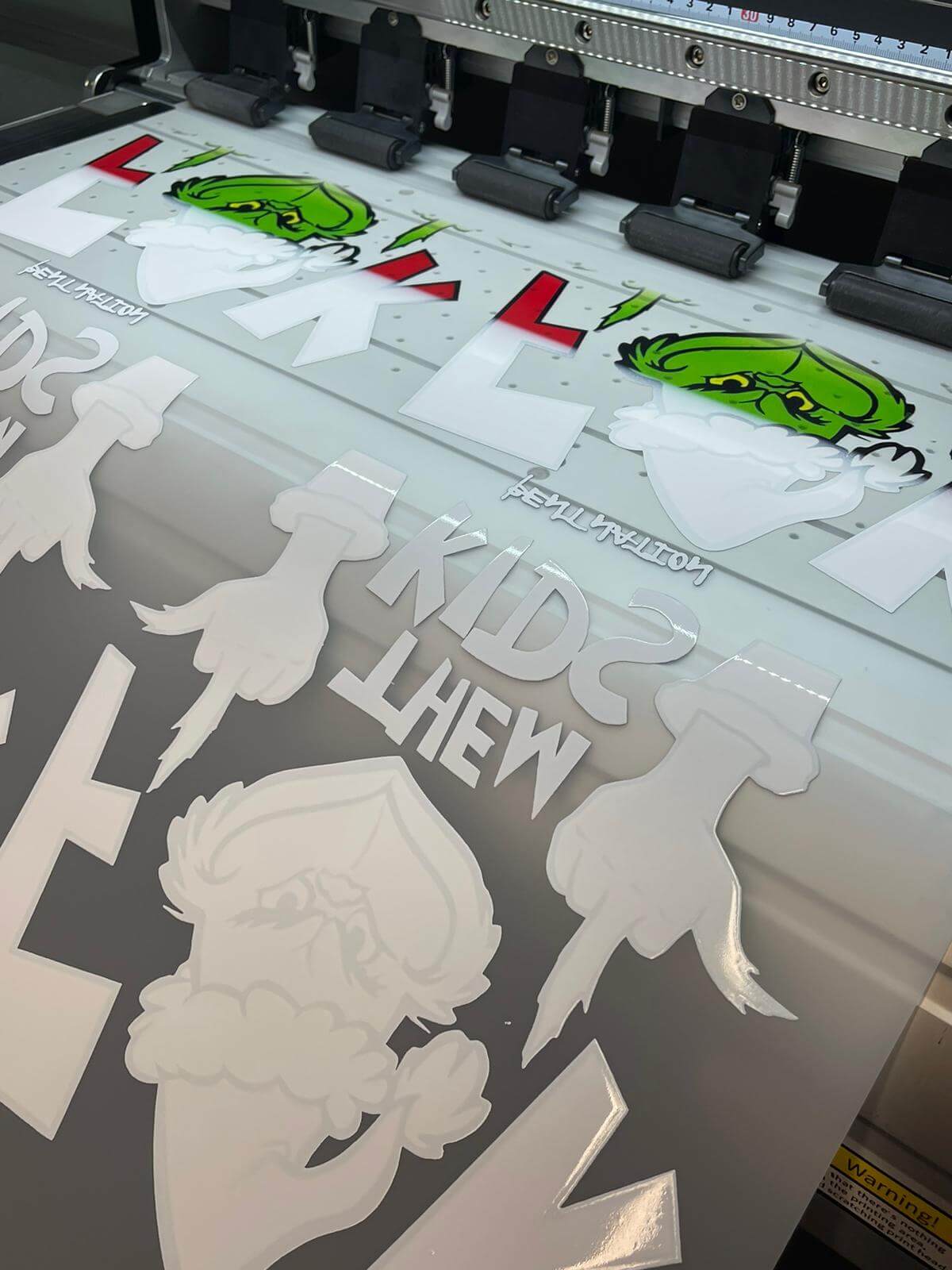 UV DTF gang sheet printing process showing colorful designs on transparent film for custom DTF transfers in California.